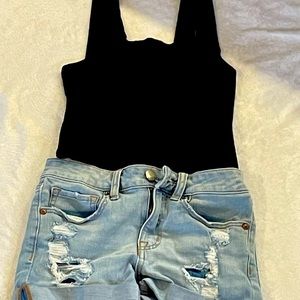 Ripped shorts and black top with thick straps